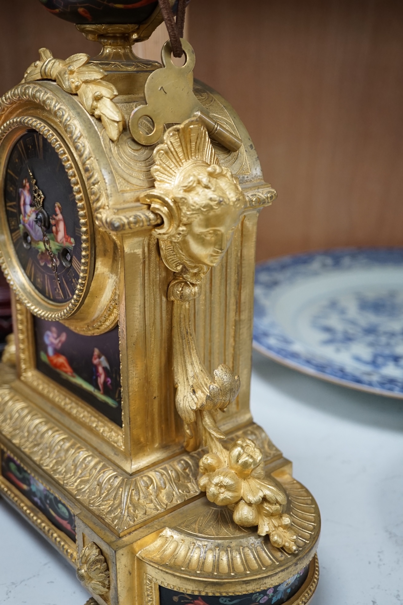 A French ormolu, black figural porcelain mounted mantel clock, 28cm wide x 36cm high. Condition - face and ormolu worn, unknown if clock working.